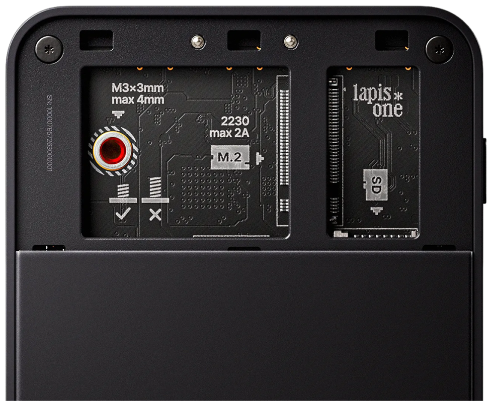 The underside of a black Lapis One with its storage cover removed, exposing the M.2 and microSD card slots.